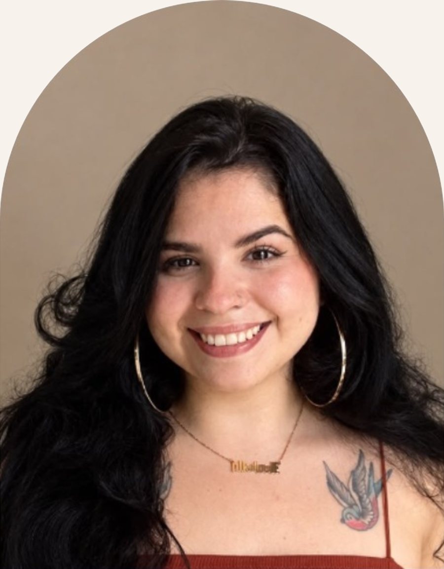 Retrato de Isabella Parras sorrindo, com cabelos pretos longos e brincos de argola